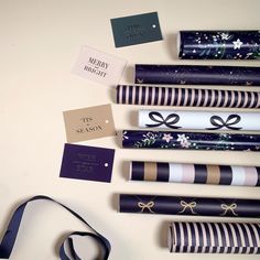 many wrapped presents are on the table with ribbons and tags attached to them, as well as gift tags