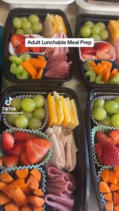 four plastic trays filled with different types of meat and fruit on top of each other