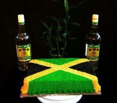 a cake made to look like the flag of jamaica with two bottles of alcohol on top