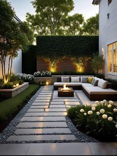 an outdoor living area with couches, fire pit and landscaping in the back yard