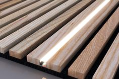 wooden slats are lined up on the floor with white light shining through one end