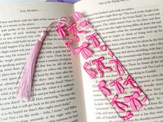 an open book with pink ribbon and tassels