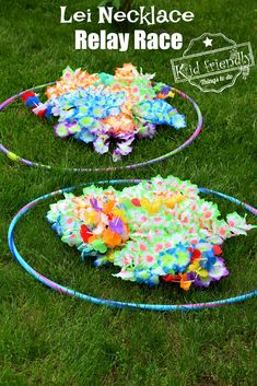 two circular hula hoops with colorful streamers on them in the grass, one has