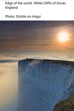 a person standing on the edge of a cliff with fog in the air behind them