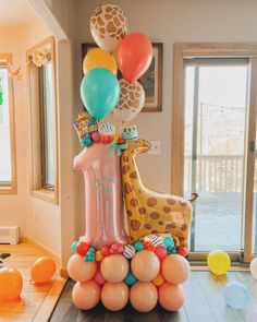 a giraffe balloon tower with balloons on top