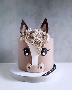 a cake decorated with a horse's head and flowers on the top is shown