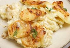 potato salad with dill sprigs on top and potatoes in the middle, served on a white plate