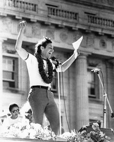 a man standing on top of a stage with his arms in the air and holding a microphone