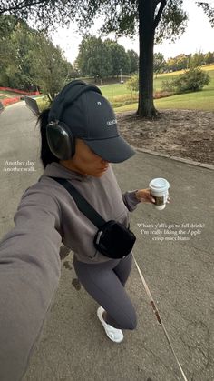 a woman with headphones is holding a cup