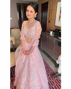 a woman in a pink gown posing for the camera