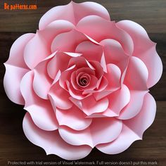 a large pink paper flower sitting on top of a wooden table