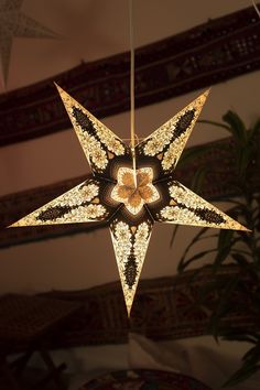 a star shaped light hanging from a ceiling