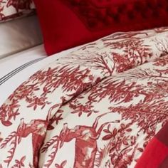 a bed with red and white comforters on top of it