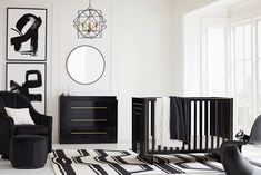 a baby's room with black furniture and art on the wall, including a crib