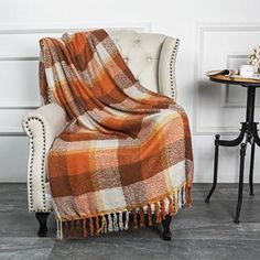 a chair with a blanket on it next to a table