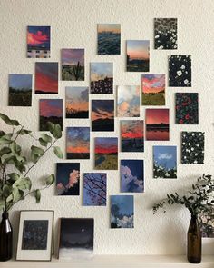 a bunch of pictures hanging on the wall next to a vase with flowers in it