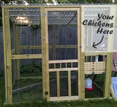 a chicken coop with the door open on grass