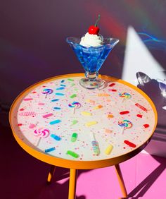 an ice cream sundae sits on top of a table with candy and candies