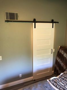 a bedroom with a sliding door next to a bed and a rug on the floor