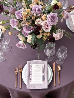 the table is set with flowers and silverware