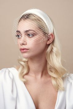 a woman wearing a white veil over her head with long blonde hair and blue eyes