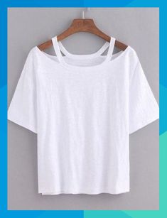 a white t - shirt hanging on a hanger against a gray wall, with the top half cut off