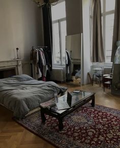 a bed room with a neatly made bed and a rug on the floor next to it