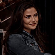 a close up of a person wearing a denim shirt and jeans jacket with long hair