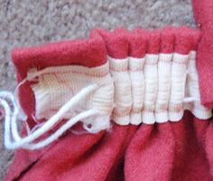 the inside of a red and white bag with some thread on it's side