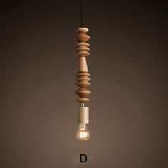 a light bulb that is hanging from a wooden structure with the letter d underneath it