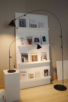 a white shelf with books and pictures on it