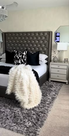 a bedroom with a large bed and black and white pillows