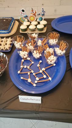 a blue plate topped with cookies and marshmallows on top of a table