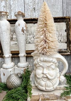 a white vase sitting on top of a wooden table next to other christmas decorations and ornaments