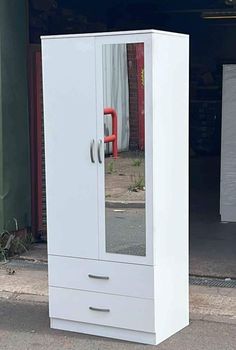 a white armoire sitting on the side of a road