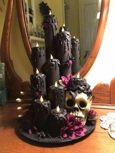 a cake that has candles in it and a skull on the side with flowers around it