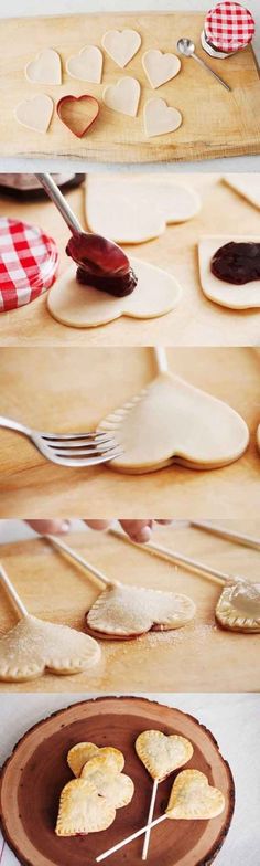 heart shaped cookies being made with cookie cutters on a wooden plate and spoon in the middle