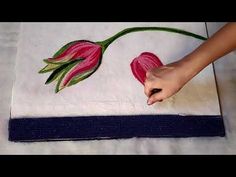 a person is painting flowers on a towel