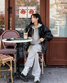 a woman sitting at a table with a drink in her hand