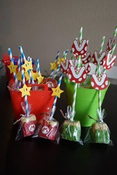 two buckets filled with candy sitting on top of a table