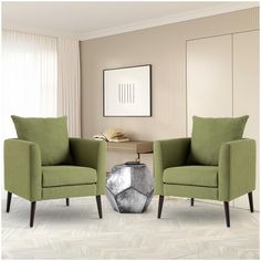 two green chairs sitting next to each other in a living room