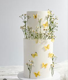 a white cake with yellow flowers and butterflies on it