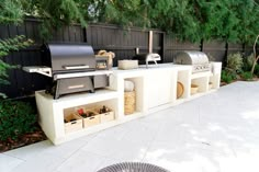 an outdoor bbq grill with lots of food on it and storage bins underneath