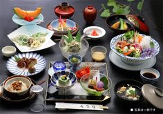 a table topped with lots of different plates and bowls filled with food next to each other