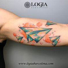 a colorful tattoo on the arm of a man with an origami paper airplane