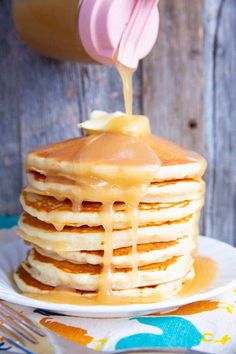 a stack of pancakes with syrup being drizzled on top