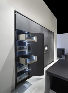 an empty kitchen with black cabinets and white tile flooring is lit up by recessed lighting