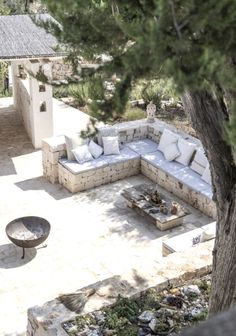 an outdoor living area with couches, tables and fire pit in the middle of it