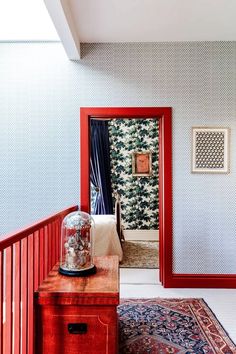 a room with a red door and rug on the floor next to an entry way