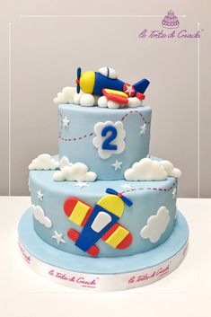 two tiered cake decorated with an airplane and clouds